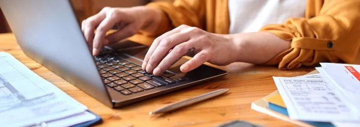 A student typing on a laptop