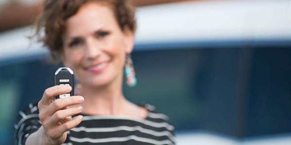 A woman holding up a car key