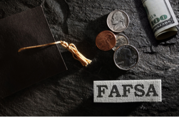 Graduation cap and money on a black background.