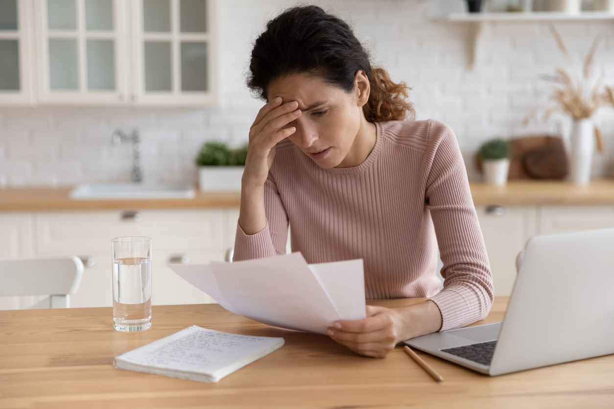 A woman in debt looking at paperwork